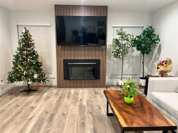 a living room with furniture a flat screen tv and a fireplace
