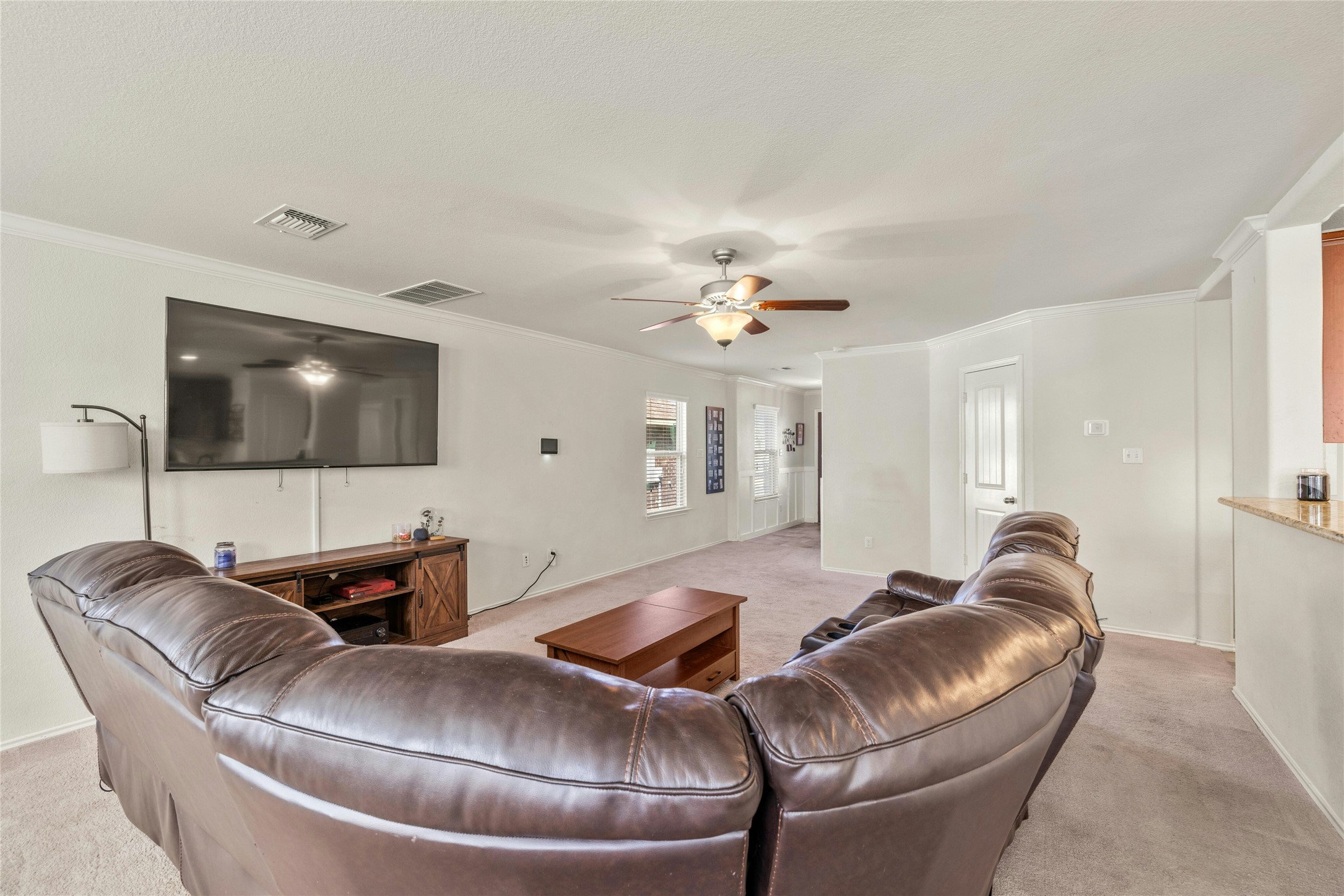 104 Bufflehead Lane Leander, TX 78641 - Photo 6 of 34 Living room featuring light carpet, ornamental molding, and a ceiling fan