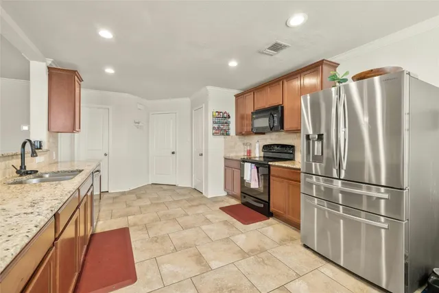 a kitchen with granite countertop a refrigerator and a sink