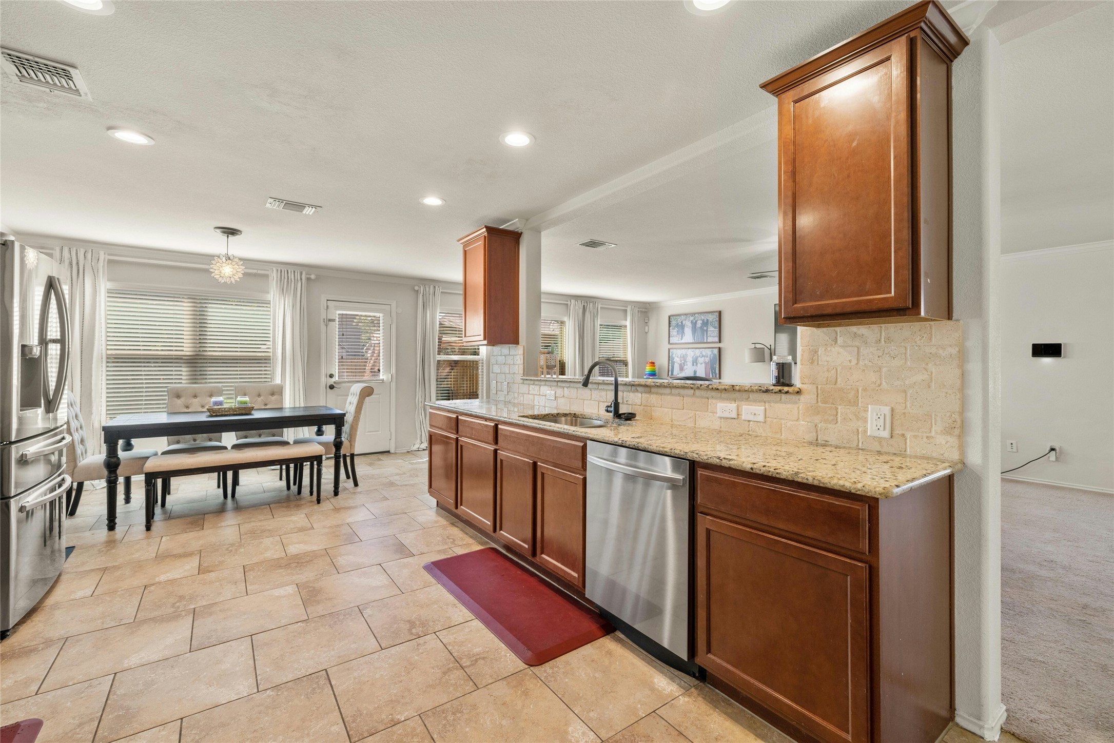 104 Bufflehead Lane Leander, TX 78641 - Photo 10 of 34 Kitchen with light stone counters, stainless steel appliances, tasteful backsplash, brown cabinets, and recessed lighting