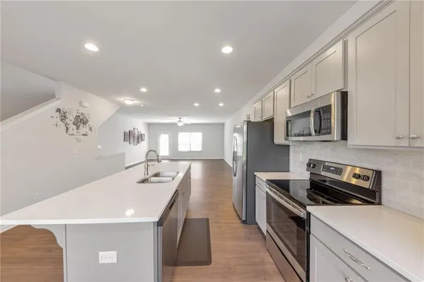 a kitchen with stainless steel appliances a stove sink microwave and cabinets