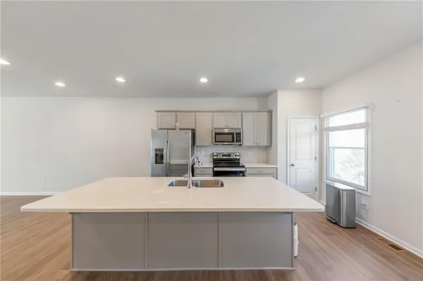 a kitchen with kitchen island a sink appliances and cabinets