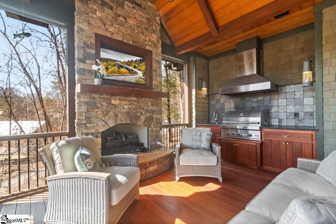 206 Feather Bell Lane Sunset, SC 29685 - Photo 12 of 50 An inviting outdoor living area with a cozy fireplace and a fully equipped kitchen.