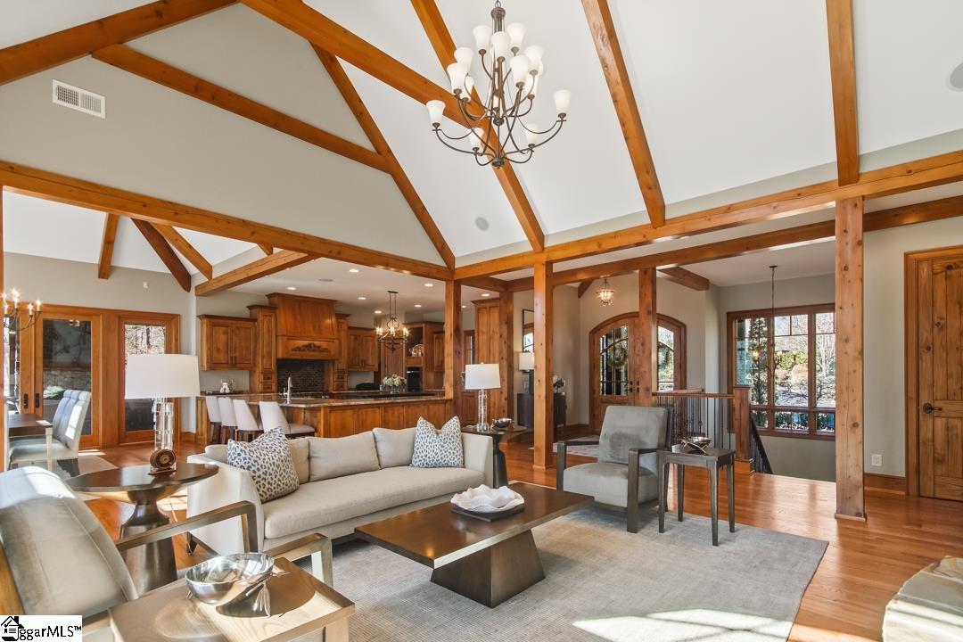 206 Feather Bell Lane Sunset, SC 29685 - Photo 15 of 50 A welcoming great room showcases soaring vaulted ceilings with exposed beams, rich hardwood floors, and an effortless flow into the kitchen—perfectly designed for relaxed gatherings and everyday living.