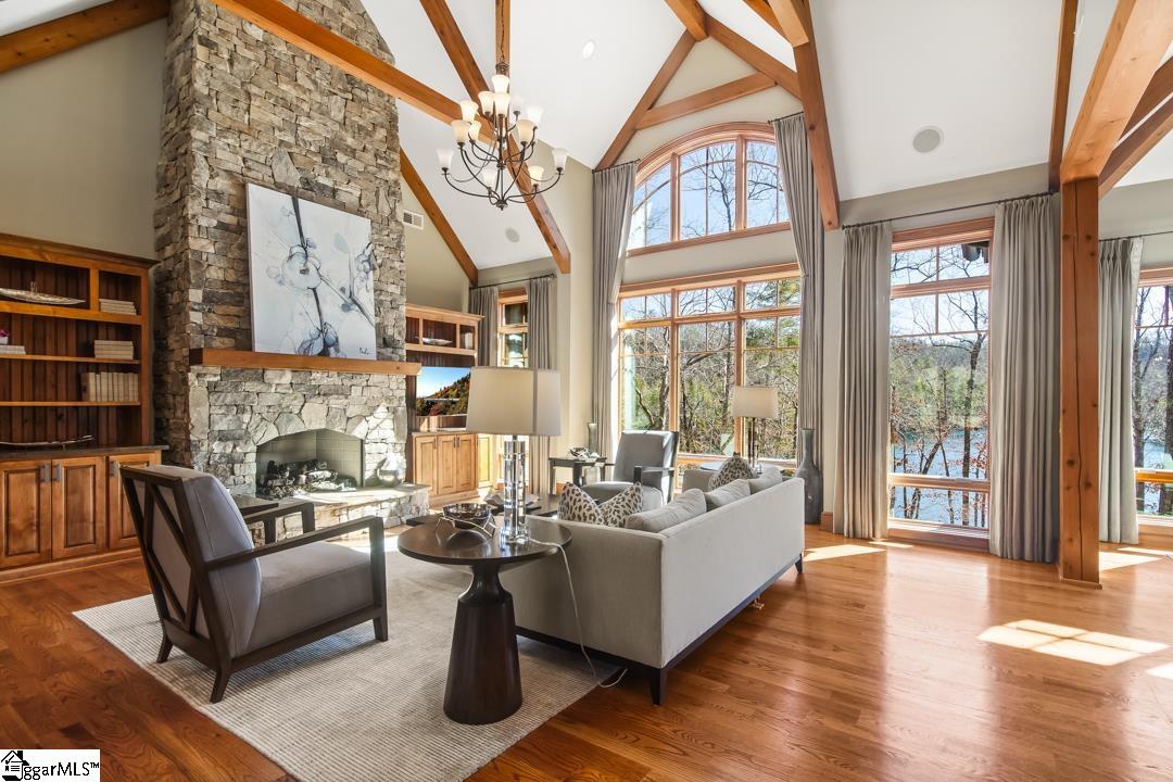 206 Feather Bell Lane Sunset, SC 29685 - Photo 17 of 50 The great room features vaulted ceilings, a stone fireplace, and panoramic views of the water.