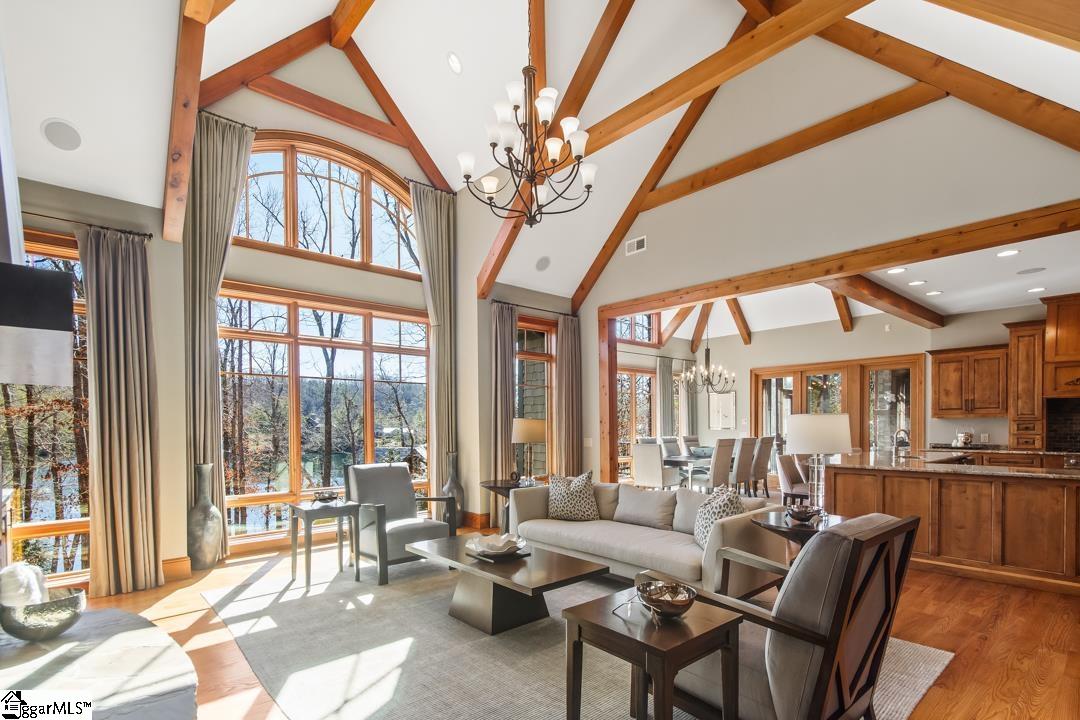 206 Feather Bell Lane Sunset, SC 29685 - Photo 18 of 50 This living space features expansive windows and vaulted ceilings with exposed wooden beams.
