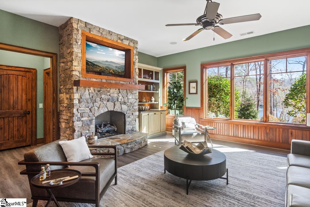 206 Feather Bell Lane Sunset, SC 29685 - Photo 28 of 50 A dramatic rec room features a soaring stone fireplace, exposed timber beams, and expansive windows that frame tranquil lake views while filling the space with natural light.
