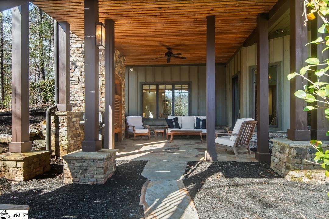 206 Feather Bell Lane Sunset, SC 29685 - Photo 38 of 50 This inviting porch offers comfortable lounging with a natural wood ceiling and stone accents.