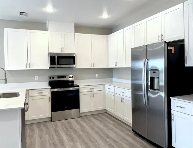 a kitchen with stainless steel appliances granite countertop a refrigerator stove and microwave