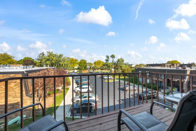 a view of a city from a balcony with outdoor seating