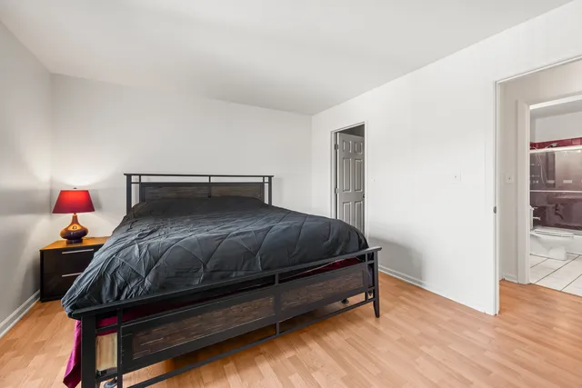 a bedroom with a bed and wooden floor