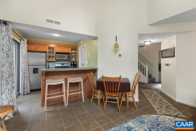 a dining room with a table chairs and a kitchen view