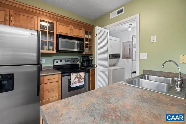 a kitchen with stainless steel appliances granite countertop a refrigerator and a stove top oven
