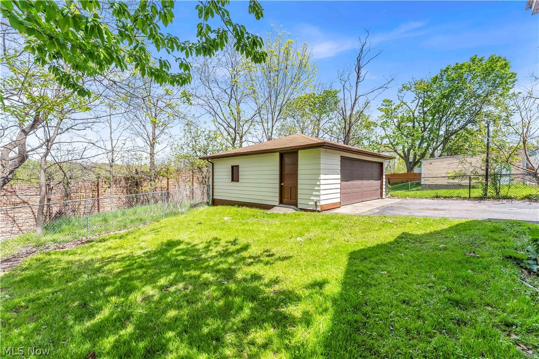 18123 McCracken Road Maple Heights, OH 44137 - Photo 27 of 27 Detached garage with a brown garage door, side entrance, and single pane window