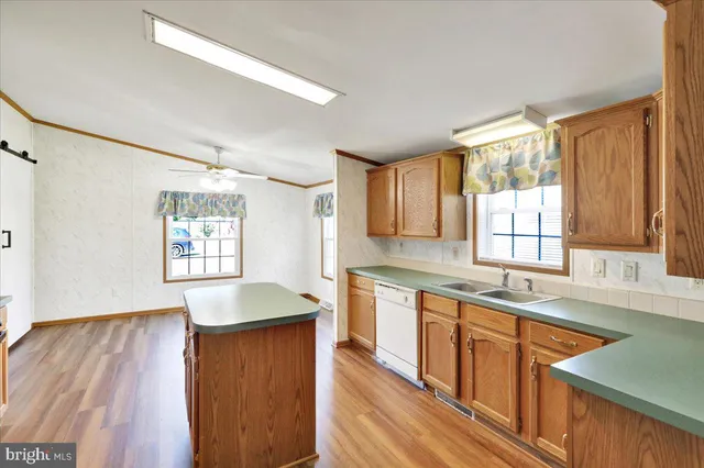 a kitchen with stainless steel appliances granite countertop wooden cabinets a sink and a large window