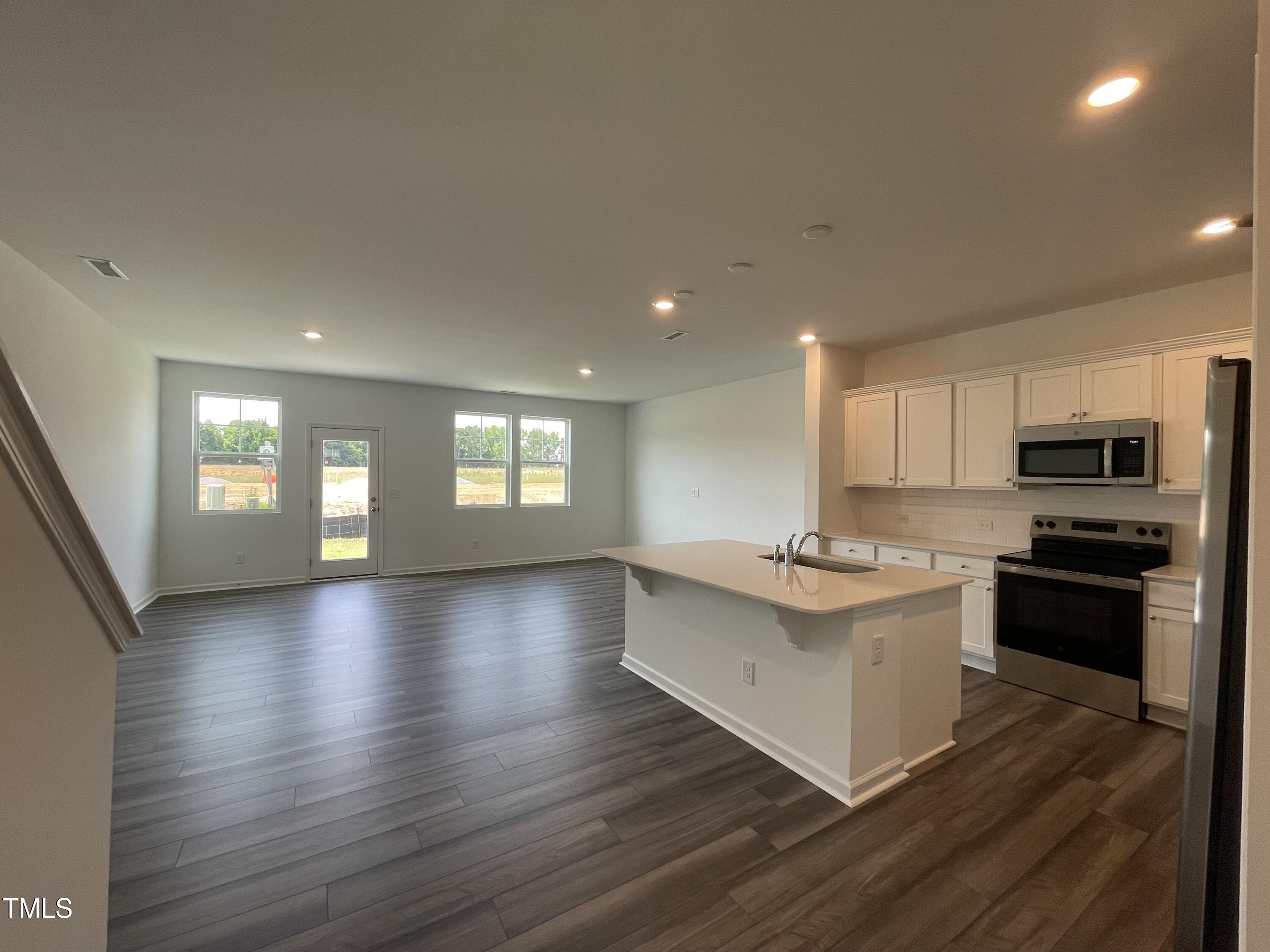 351 Thompson Overlook Way Smithfield, NC 27577 - Photo 4 of 11 a kitchen with stainless steel appliances granite countertop a stove and a wooden floors