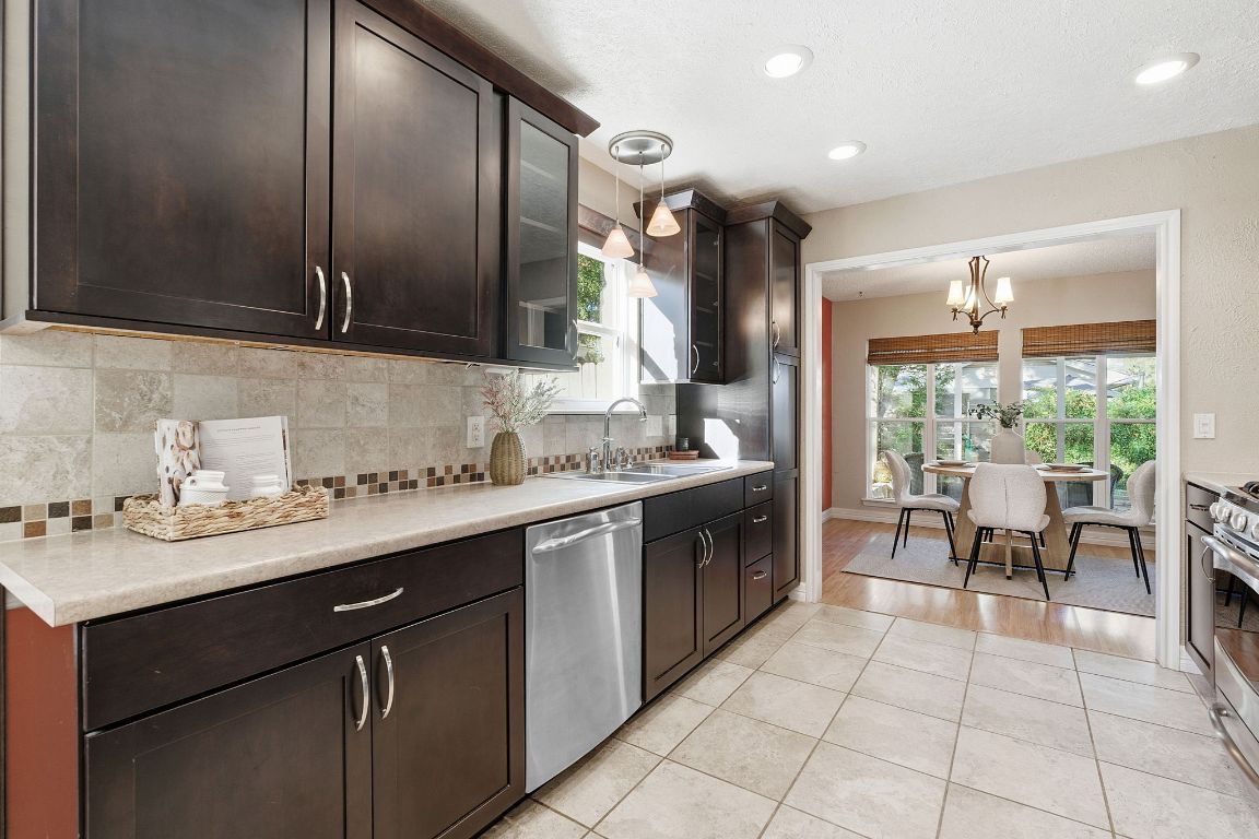 4706 Cap Rock Drive Austin, TX 78735 - Photo 11 of 40 a kitchen with a sink window and cabinets