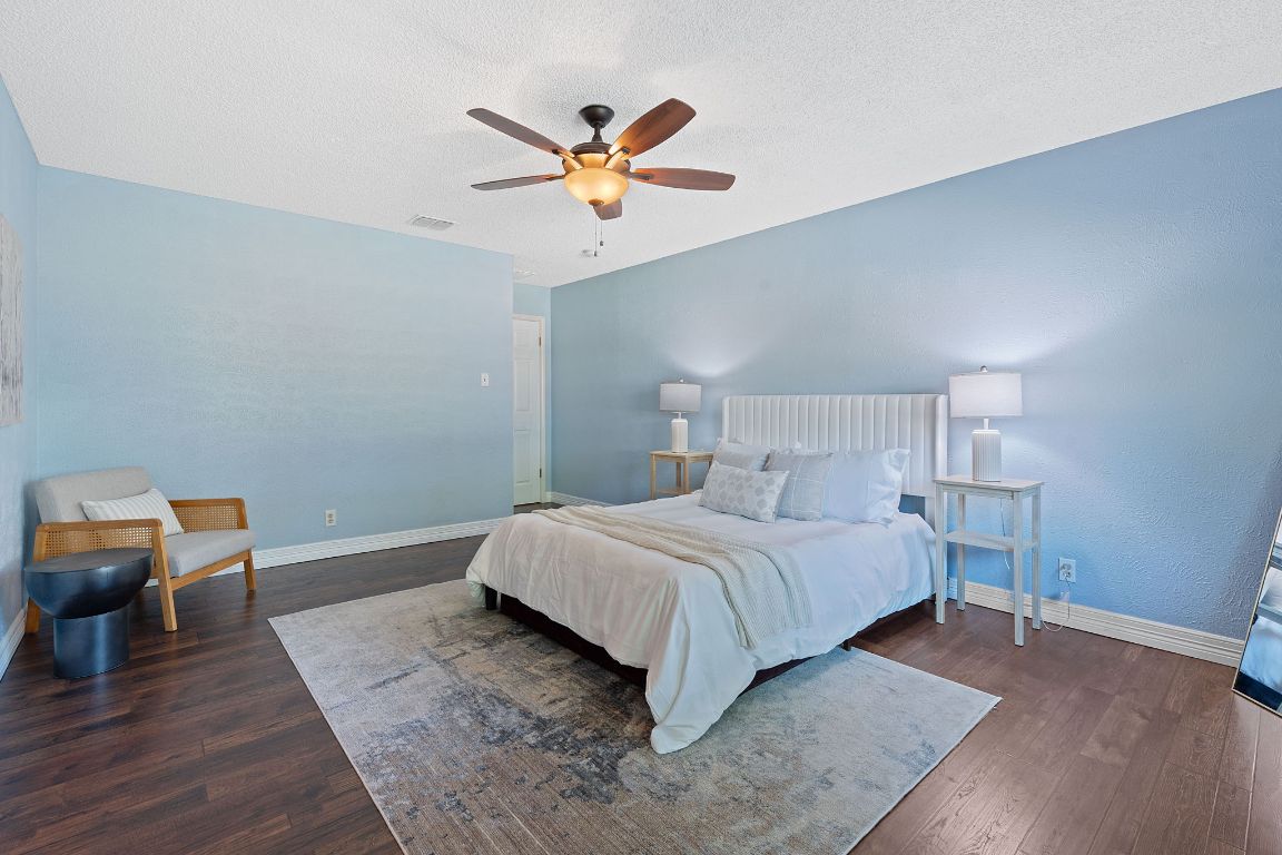 4706 Cap Rock Drive Austin, TX 78735 - Photo 15 of 40 a bedroom with a bed and wooden floor