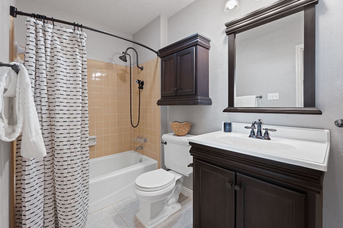 4706 Cap Rock Drive Austin, TX 78735 - Photo 21 of 40 a bathroom with a sink a toilet a mirror and shower