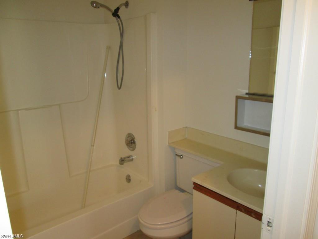 5355 Treetops Drive, Unit S201 Naples, FL 34113 - Photo 3 of 7 a bathroom with a granite countertop bathtub shower sink vanity and toilet