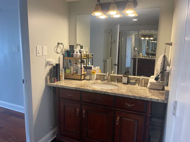 a bathroom with a granite countertop sink and a mirror