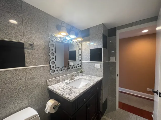 a bathroom with a sink a toilet and mirror