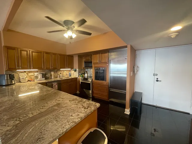 a kitchen with stainless steel appliances granite countertop a sink a stove and a refrigerator