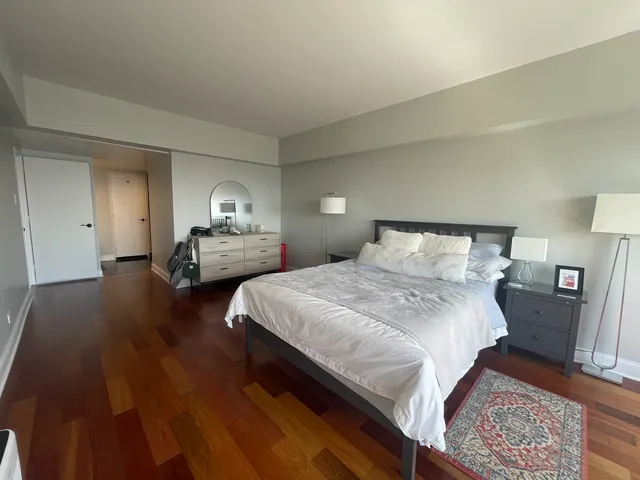 a bedroom with a bed and wooden floor