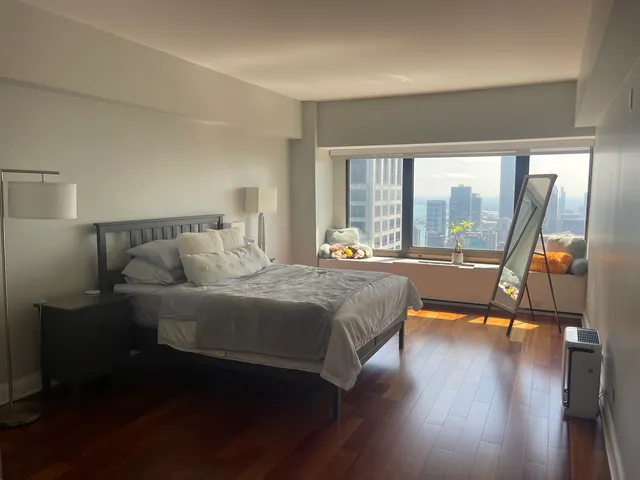 a bedroom with a bed and a large window