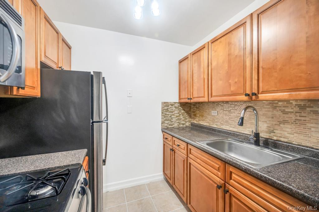 3123 Bailey Avenue, Unit 4A Bronx, NY 10463 - Photo 13 of 27 a kitchen with stainless steel appliances granite countertop a sink stove and refrigerator