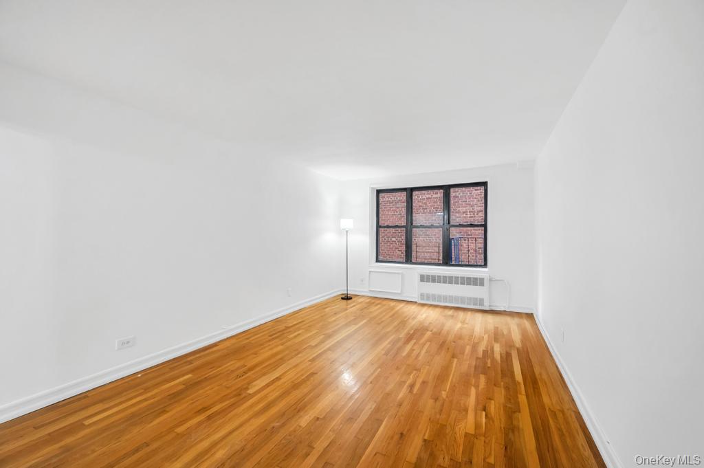3123 Bailey Avenue, Unit 4A Bronx, NY 10463 - Photo 5 of 27 a view of an empty room with a window and wooden floor