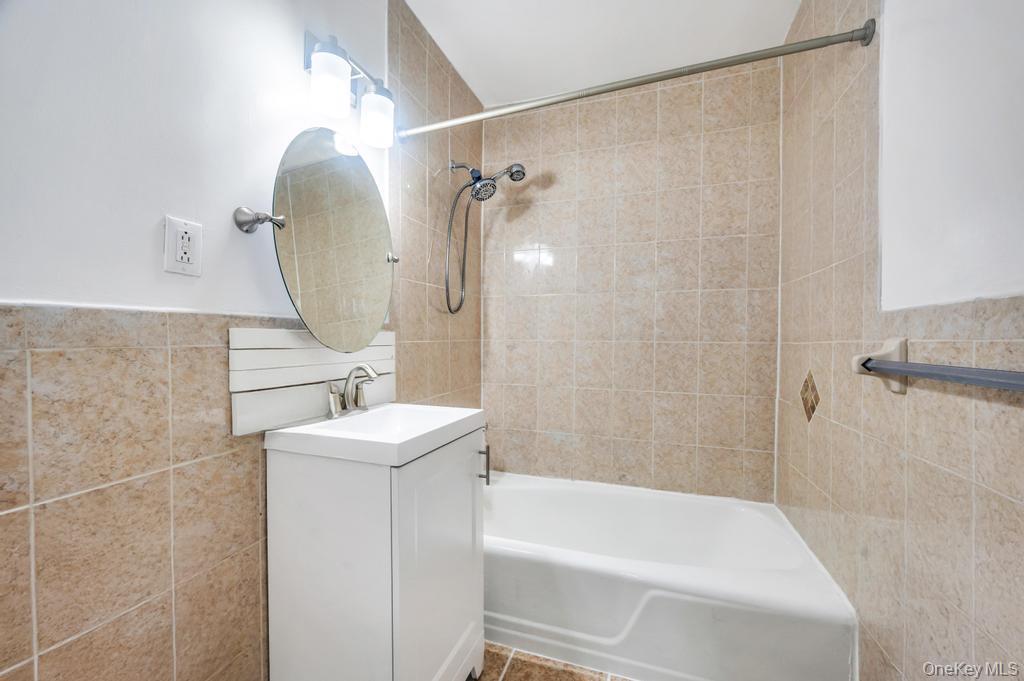 3123 Bailey Avenue, Unit 4A Bronx, NY 10463 - Photo 10 of 27 a bathroom with a sink a mirror a bathtub and shower