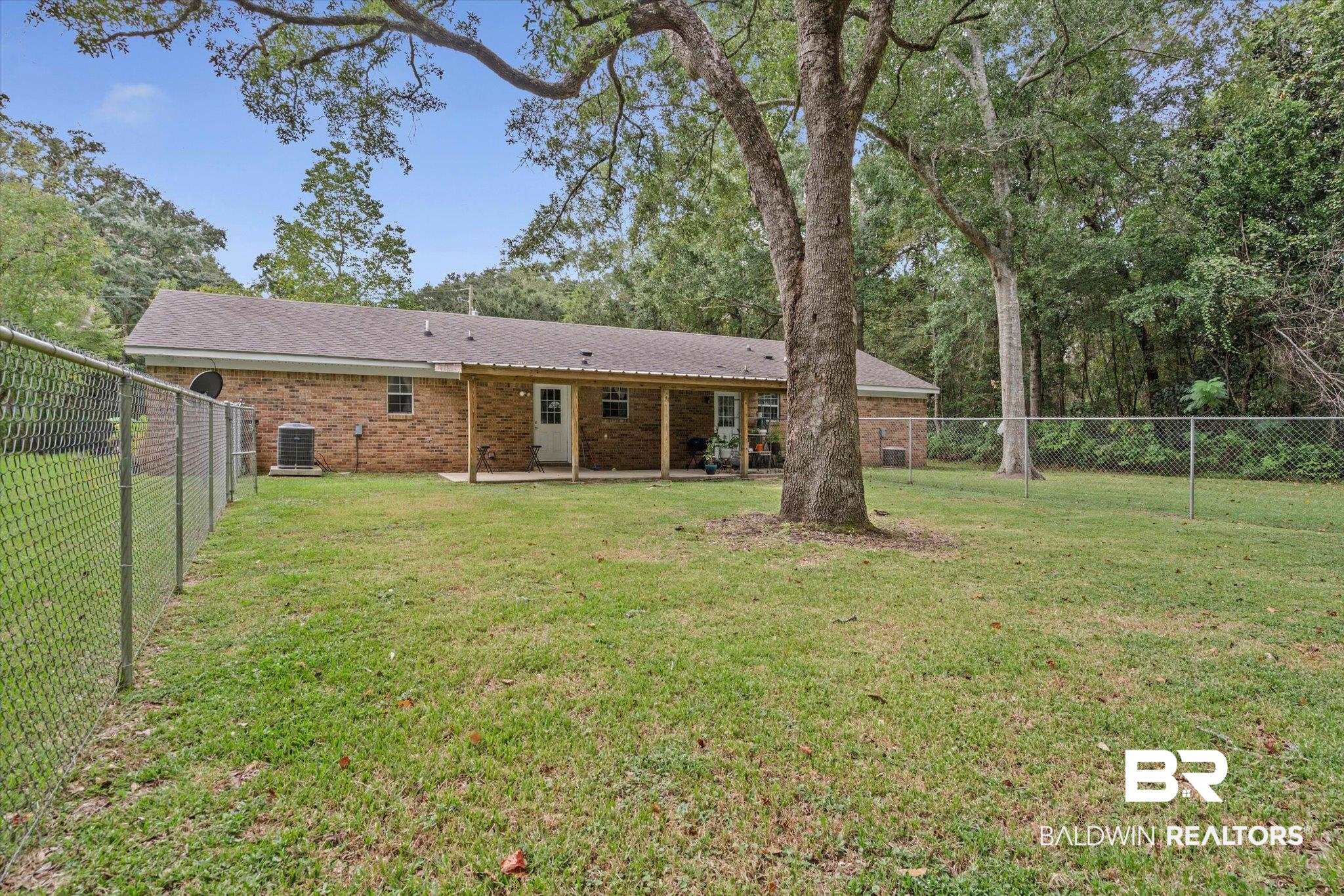 14165 River Oaks Road, Unit A & B Coden, AL 36523 - Photo 22 of 35 Rear view of property with a fenced backyard, a patio, brick siding, a shingled roof, and view of scattered trees