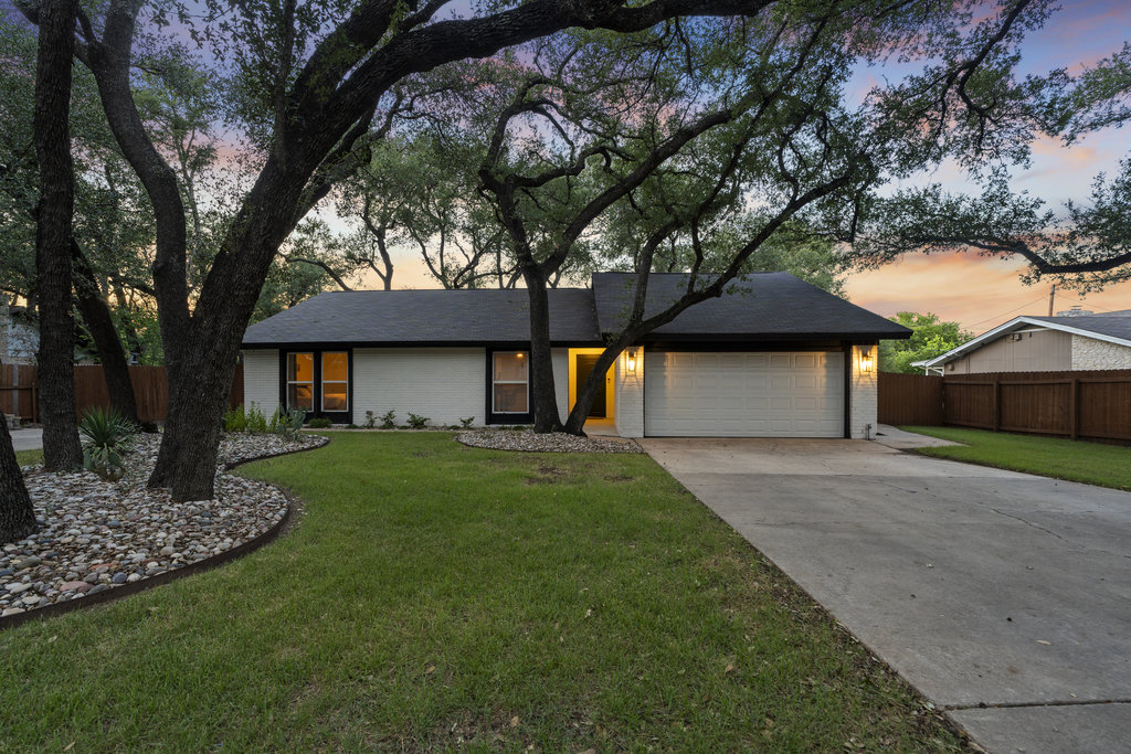 9308 Meadowheath Drive Austin, TX 78729 - Photo 1 of 40 a front view of a house with a yard and garage