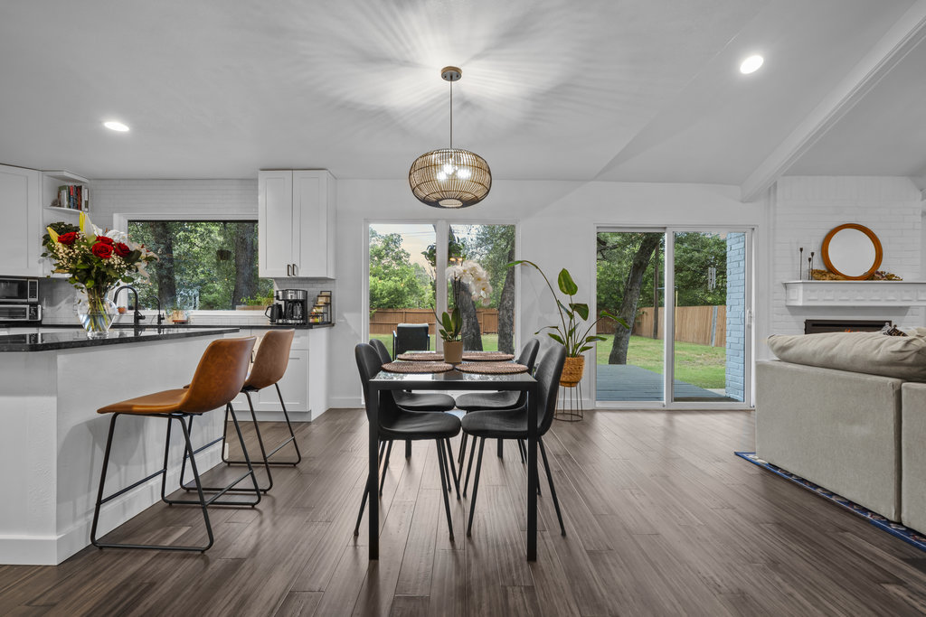 9308 Meadowheath Drive Austin, TX 78729 - Photo 12 of 40 a dining room with wooden floor a chandelier a glass table and chairs