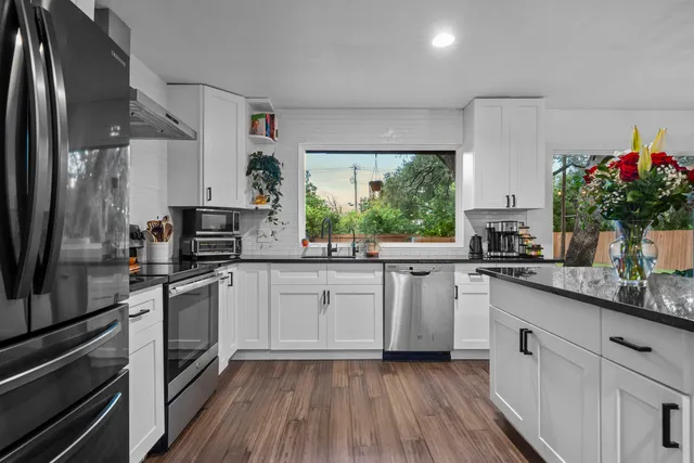 a kitchen with a sink stainless steel appliances and white cabinets