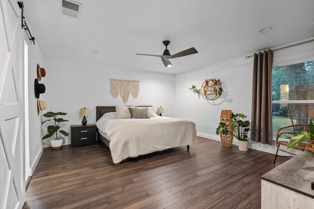 a bedroom with a bed and wooden floor