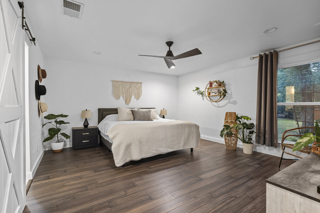 9308 Meadowheath Drive Austin, TX 78729 - Photo 21 of 40 a bedroom with a bed and wooden floor