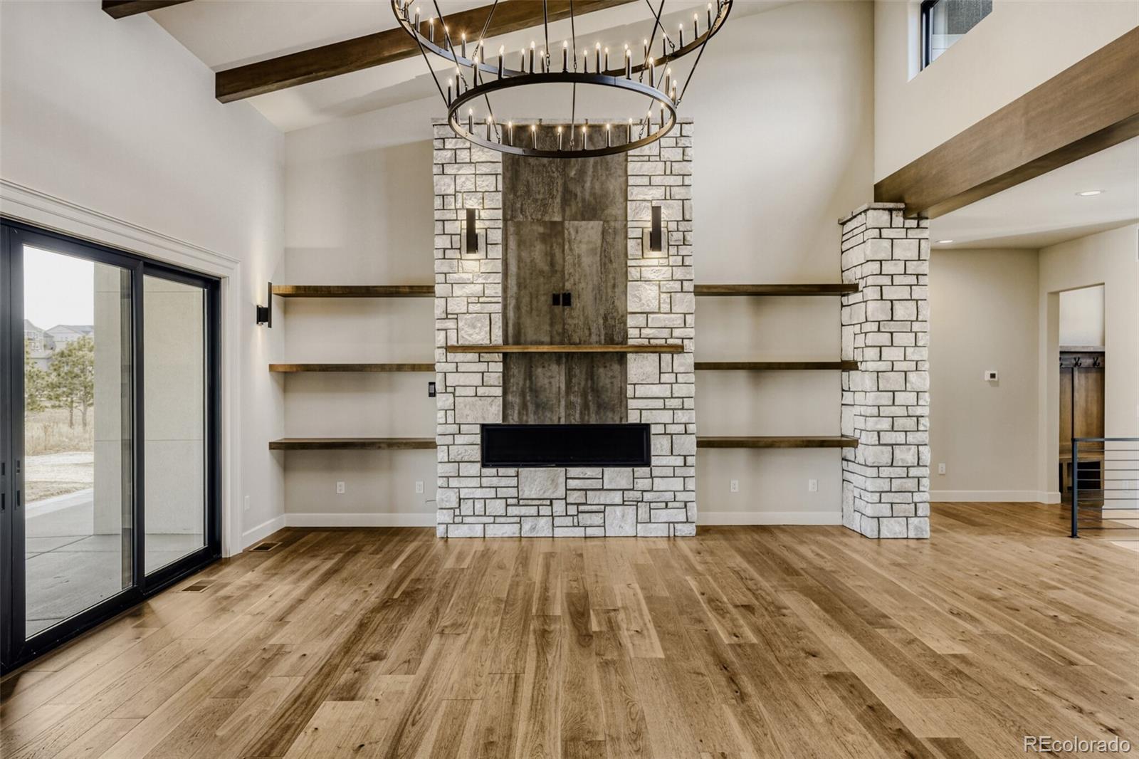 5796 Powell Road Parker, CO 80134 - Photo 11 of 50 a view of empty room with wooden floor and kitchen view