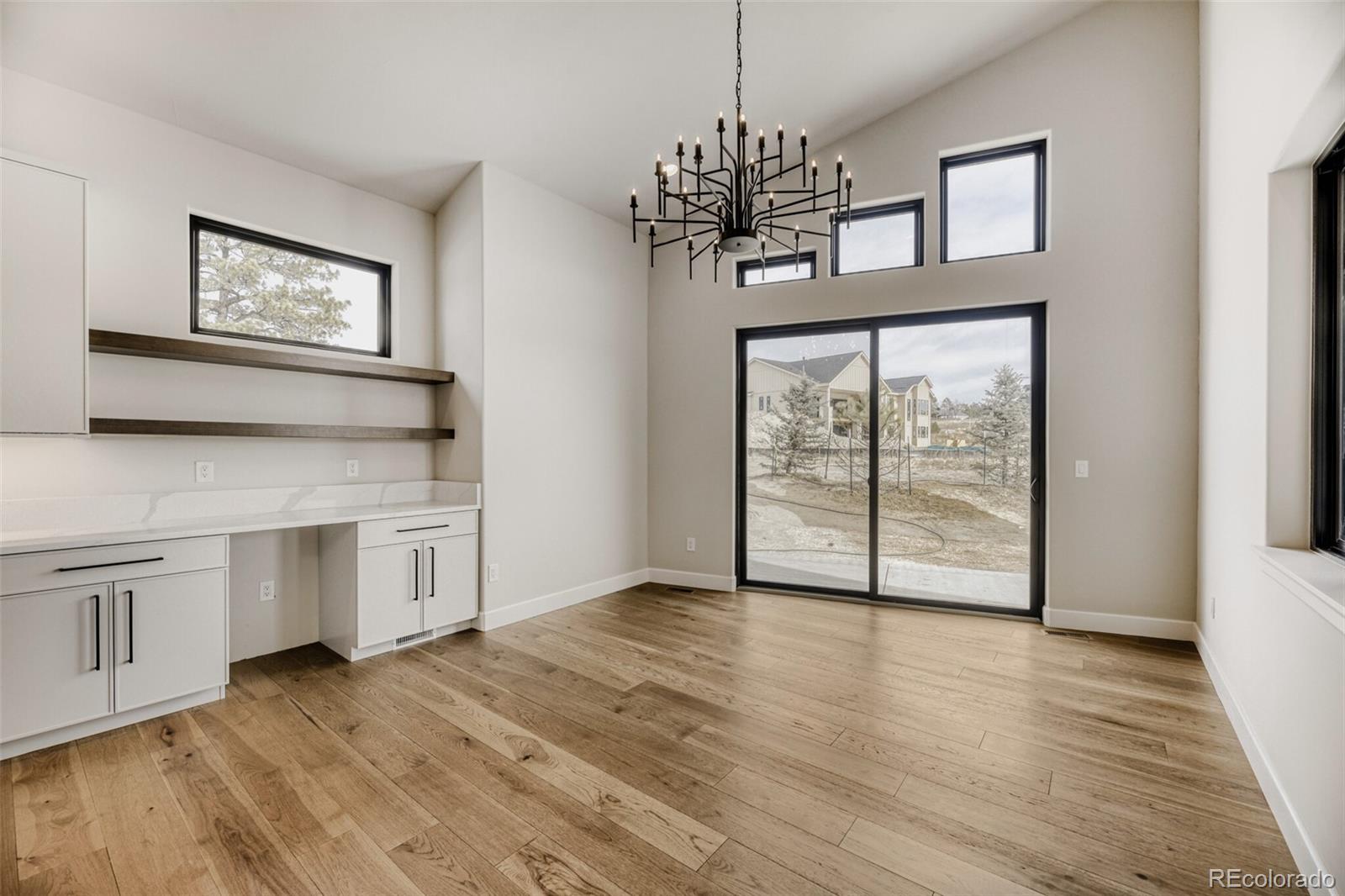 5796 Powell Road Parker, CO 80134 - Photo 18 of 50 a view of a room with wooden floors and chandelier
