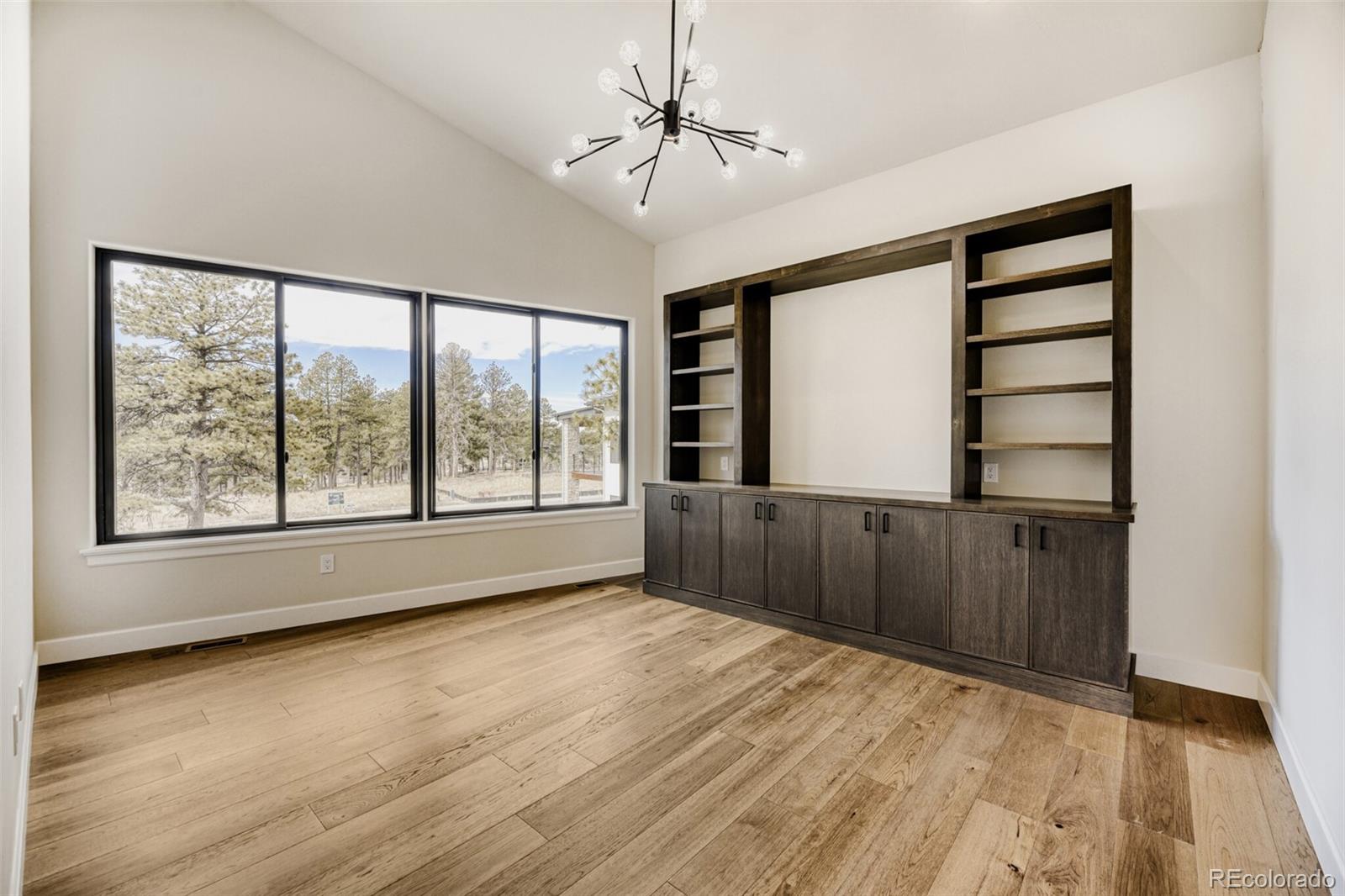 5796 Powell Road Parker, CO 80134 - Photo 20 of 50 a view of an empty room with a window and wooden floor