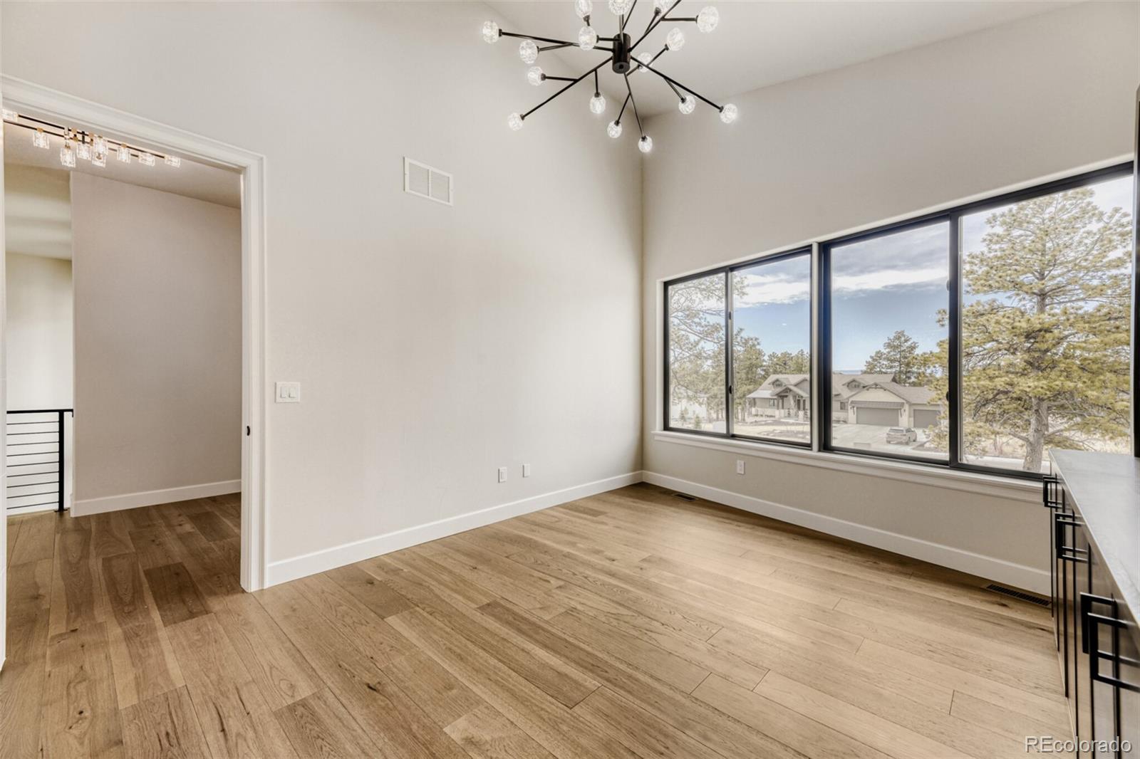 5796 Powell Road Parker, CO 80134 - Photo 21 of 50 an empty room with wooden floor fan and windows
