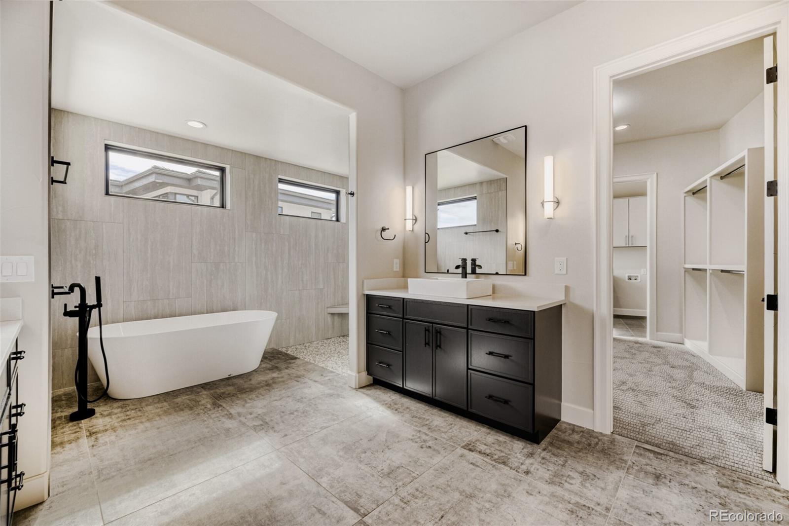 5796 Powell Road Parker, CO 80134 - Photo 25 of 50 a bathroom with a tub sink shower and mirror