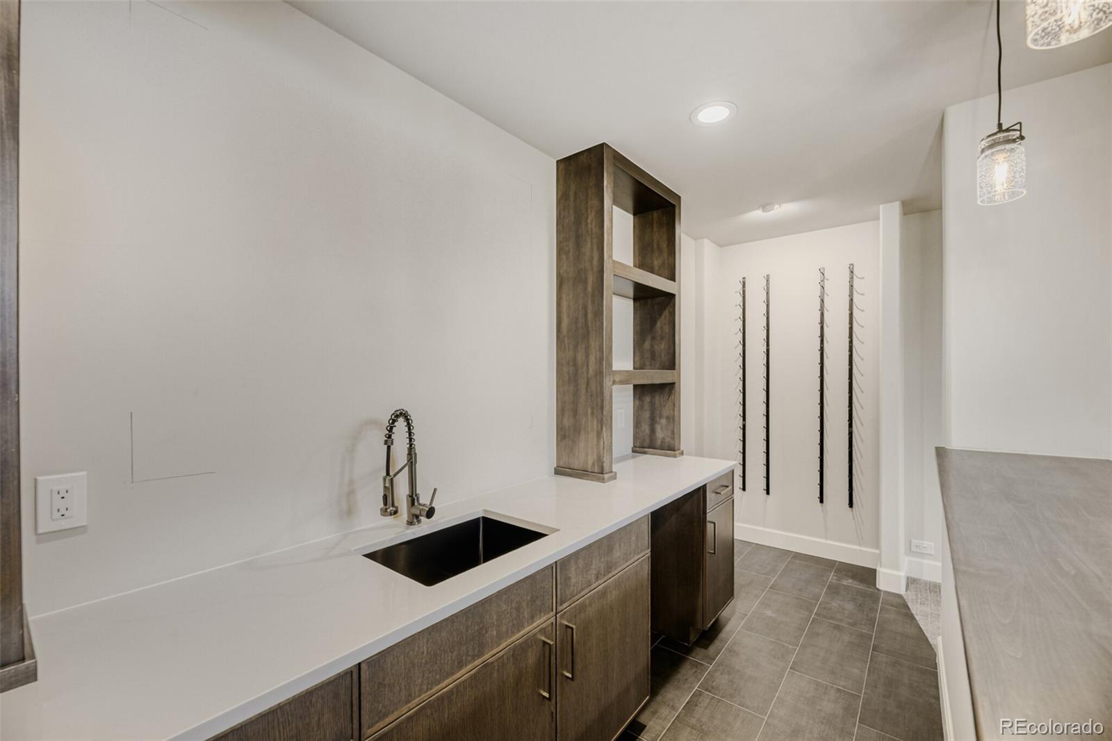 5796 Powell Road Parker, CO 80134 - Photo 35 of 50 a kitchen with a sink a refrigerator and cabinets
