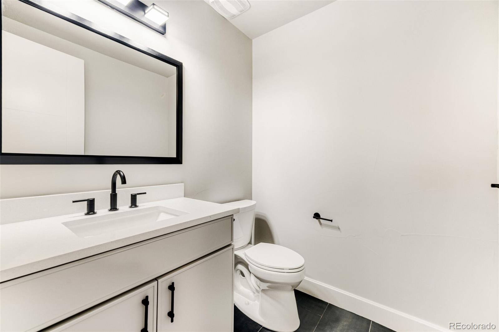 5796 Powell Road Parker, CO 80134 - Photo 37 of 50 a bathroom with a toilet a sink and mirror