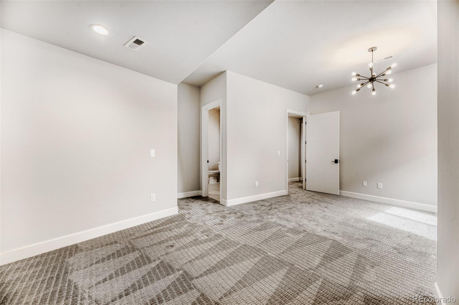 5796 Powell Road Parker, CO 80134 - Photo 41 of 50 an empty room with a chandelier fan and windows