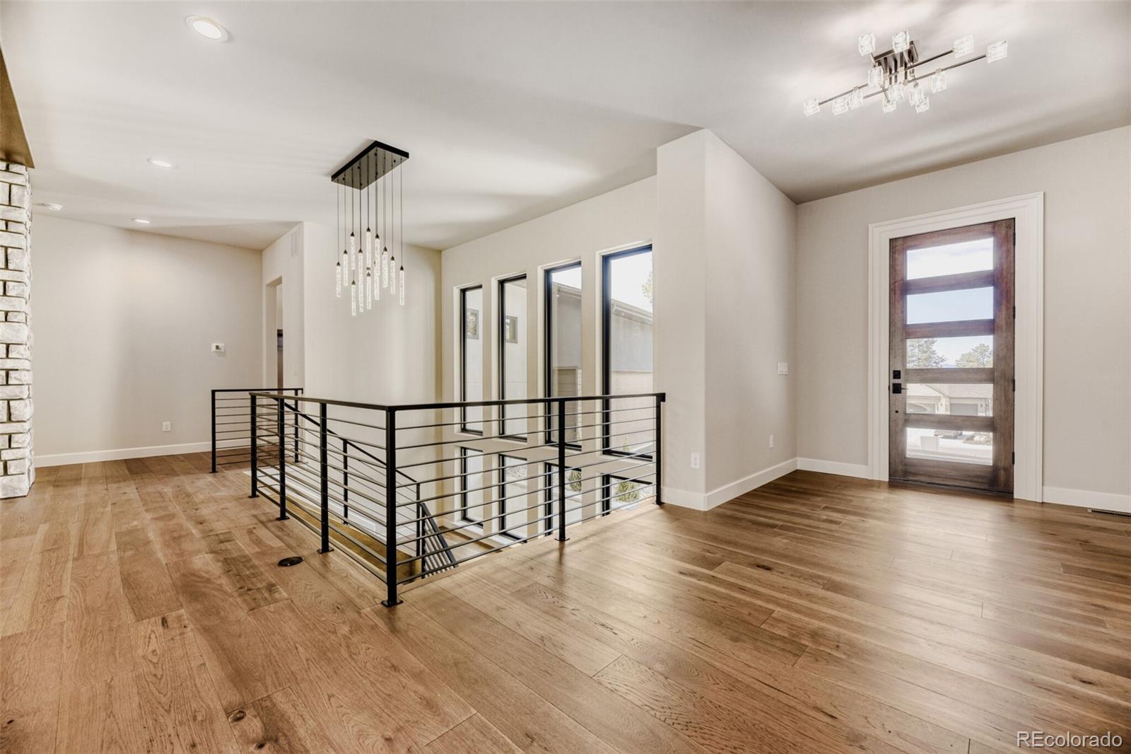 5796 Powell Road Parker, CO 80134 - Photo 5 of 50 an empty room with wooden floor fan and windows