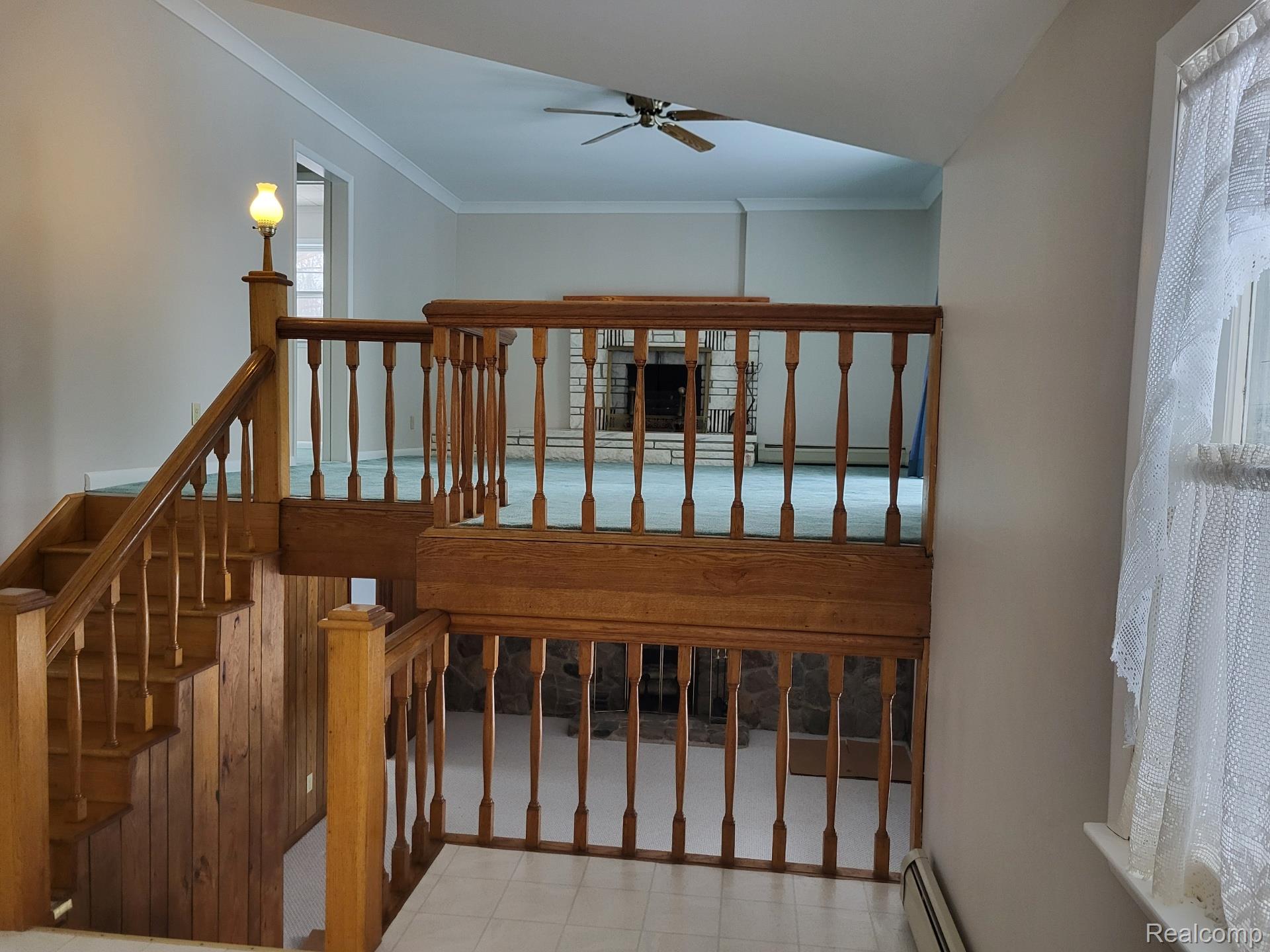 4662 North Lapeer Road Columbiaville, MI 48421 - Photo 5 of 19 Stairs with a baseboard heating unit, crown molding, and a ceiling fan