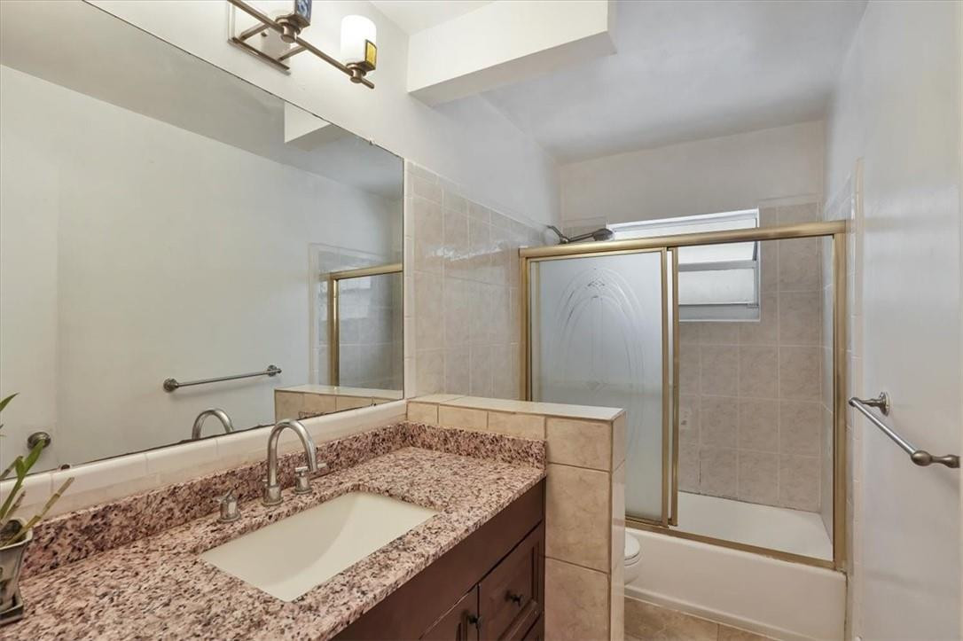 830 Southwest 50th Avenue Margate, FL 33068 - Photo 21 of 30 a bathroom with a granite countertop sink a mirror and shower