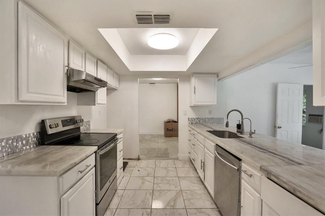 830 Southwest 50th Avenue Margate, FL 33068 - Photo 7 of 30 a kitchen with a sink dishwasher stove and white cabinets